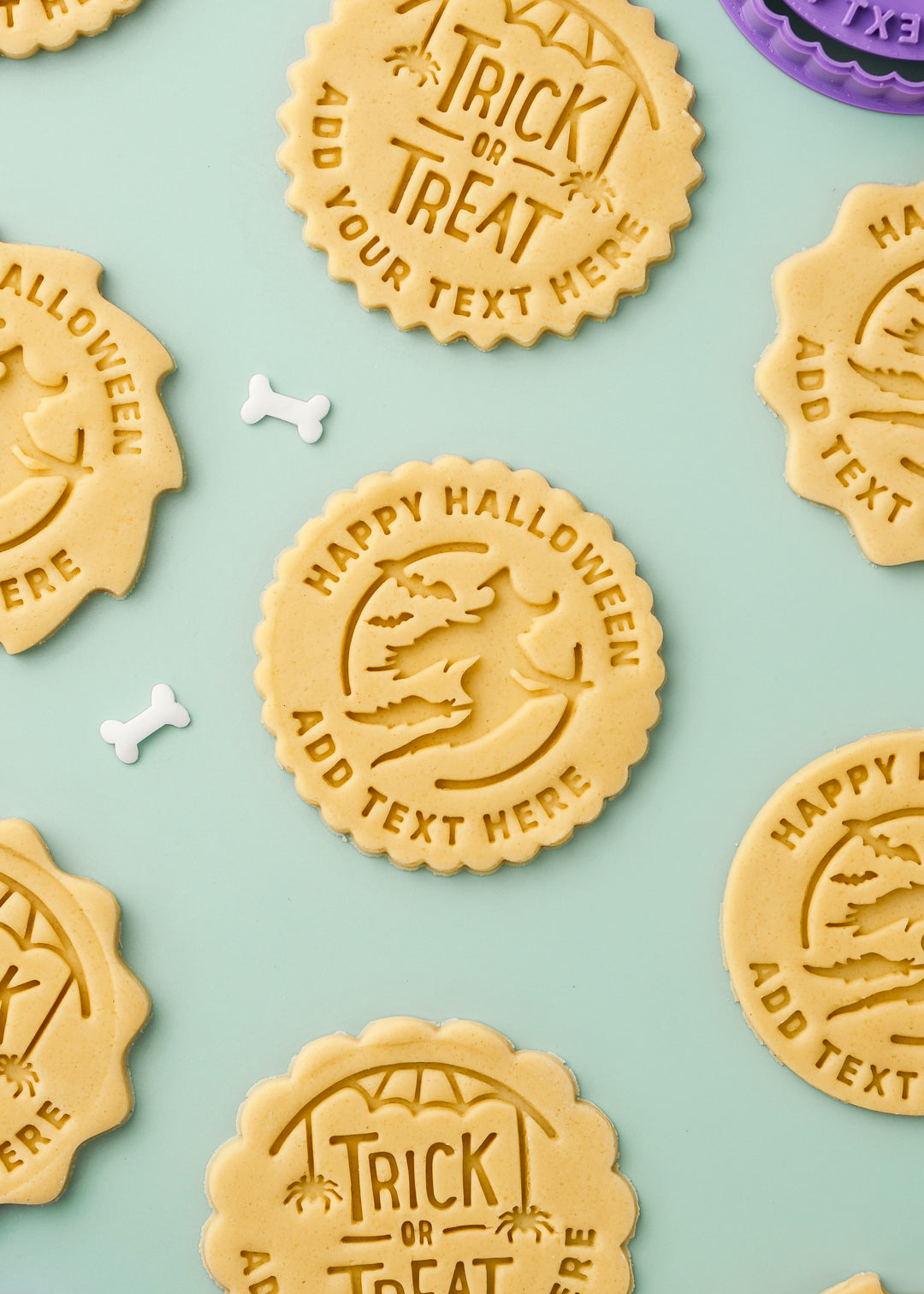 Halloween-themed cookies with customizable text on a light blue background