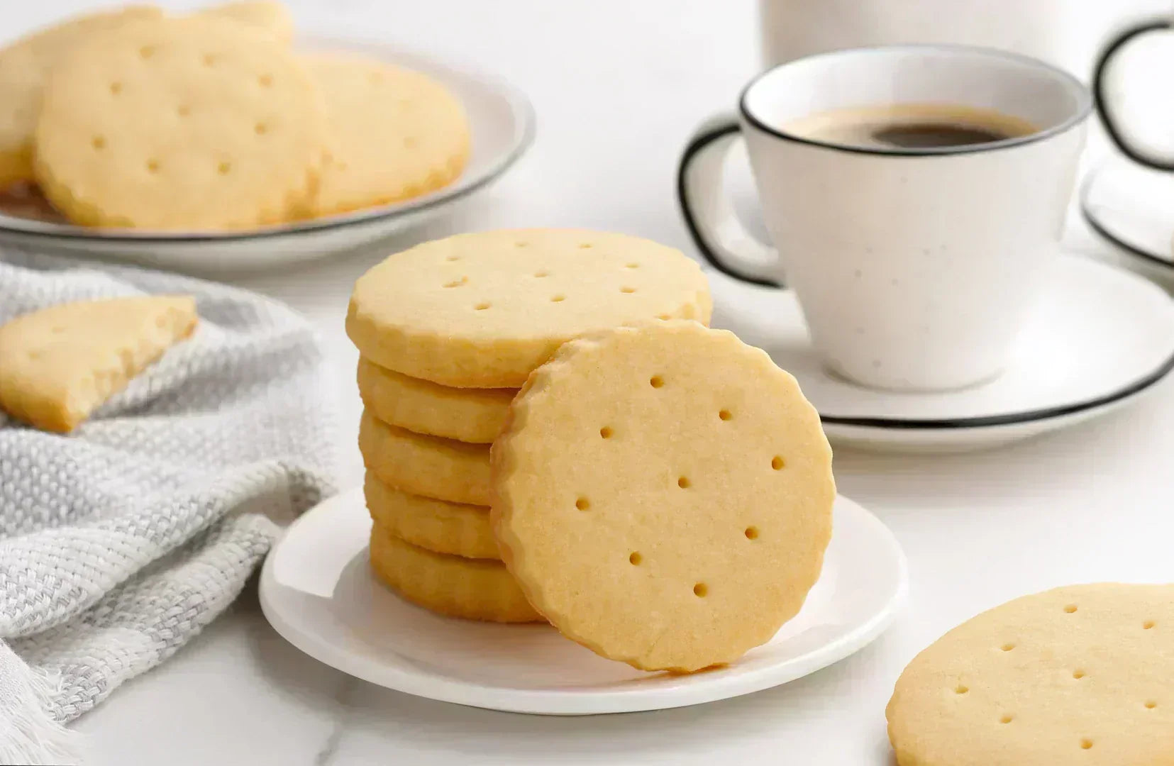 A stack of Classic Shortbread Cookies with Coffee mug in the background