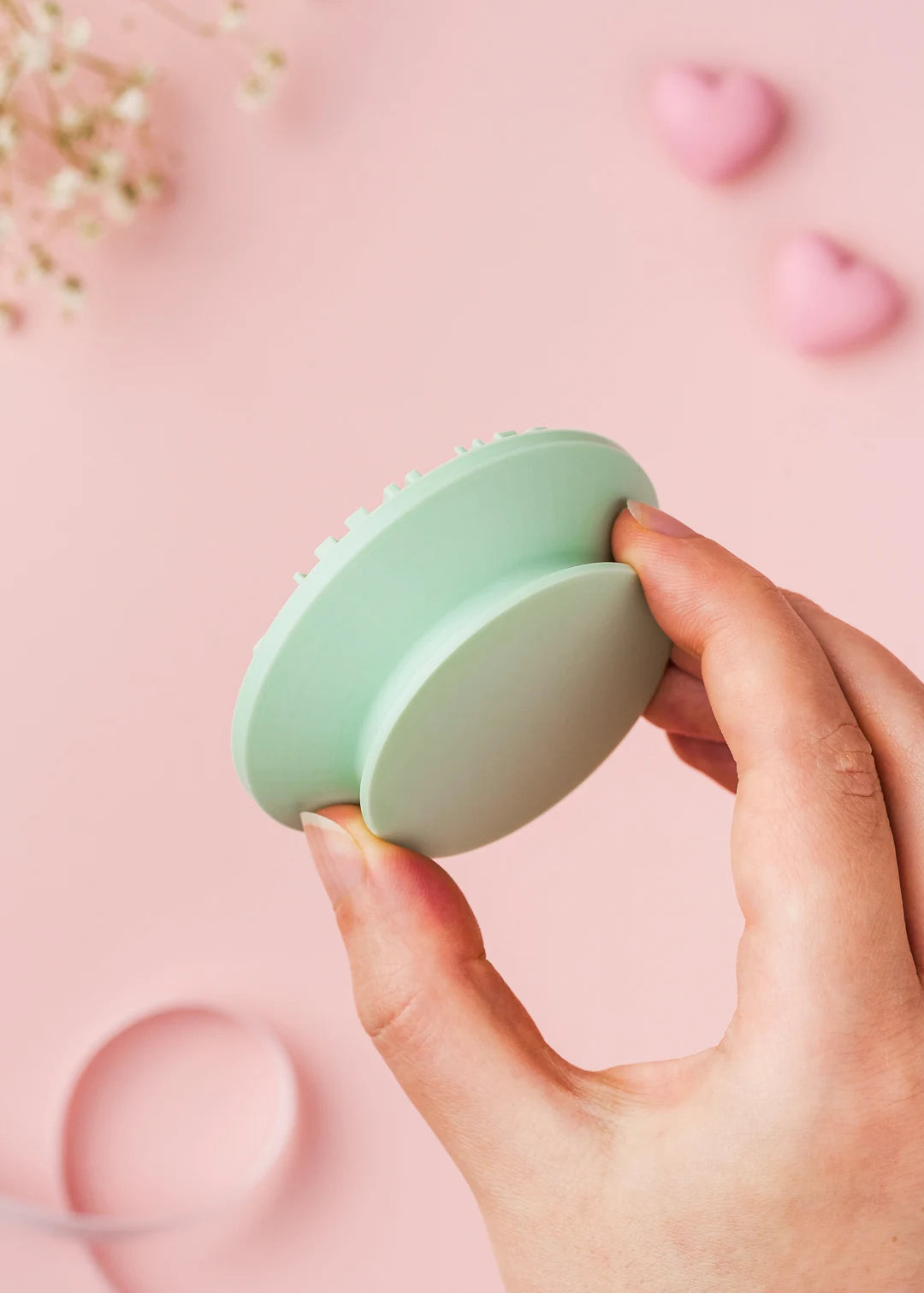 Close-up of a mint green cookie stamp held in hand, featuring an easy-grip handle for comfortable and precise stamping. Thoughtfully designed for effortless baking with beautiful results.