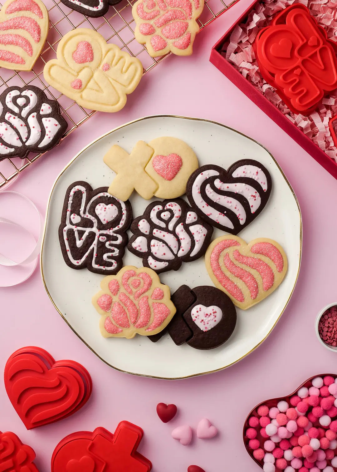 Valentine's Day cookies served on a plate – A plate of heart-shaped and rose cookies decorated with pink icing and sprinkles, surrounded by 3D-printed cookie cutters, creating a perfect Valentine's Day treat setting.