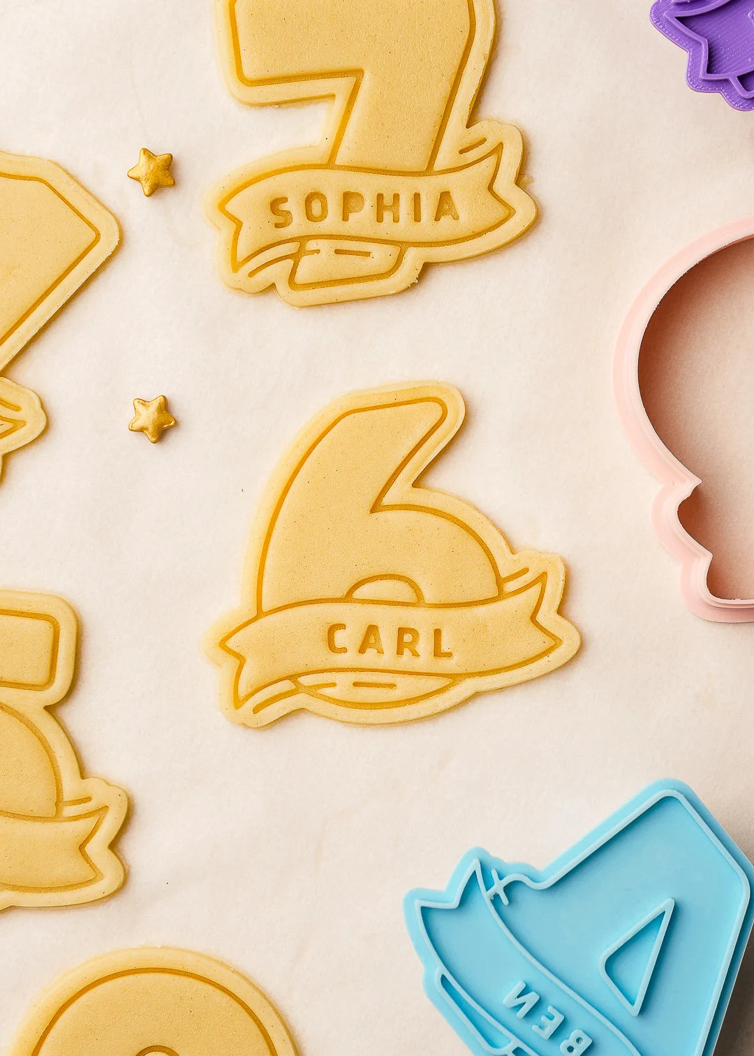 Number-shaped cookie dough with embossed names 'Carl' and 'Sophia', precisely cut using custom 3D printed cookie cutters. Perfect for birthday party baking and personalized treats.