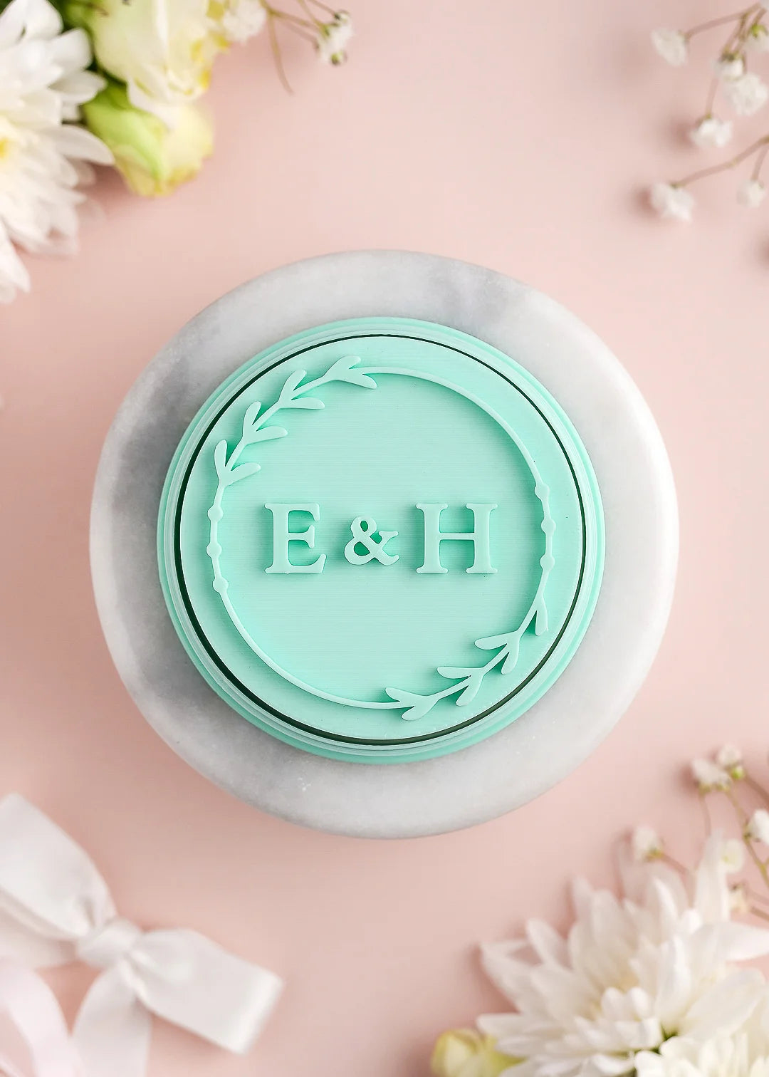 Round wedding cookie stamp with floral frame and custom initials. Example: E&H