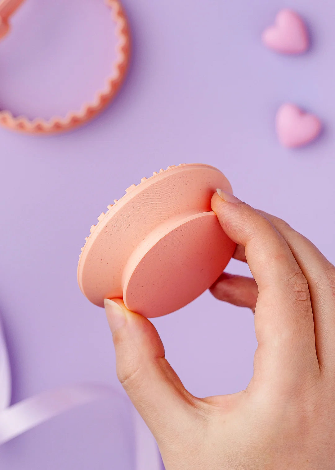 Hand holding cookie stamp, showing its ergonomic handle design