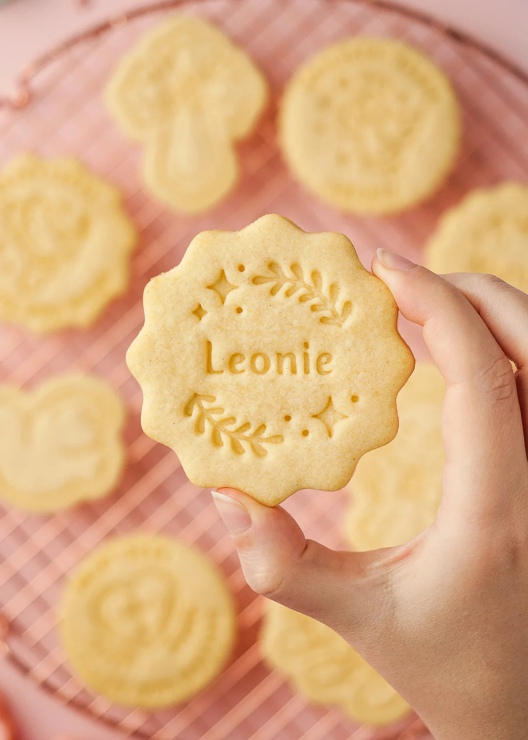 Hand holding a personalized cookie with the name Leonie