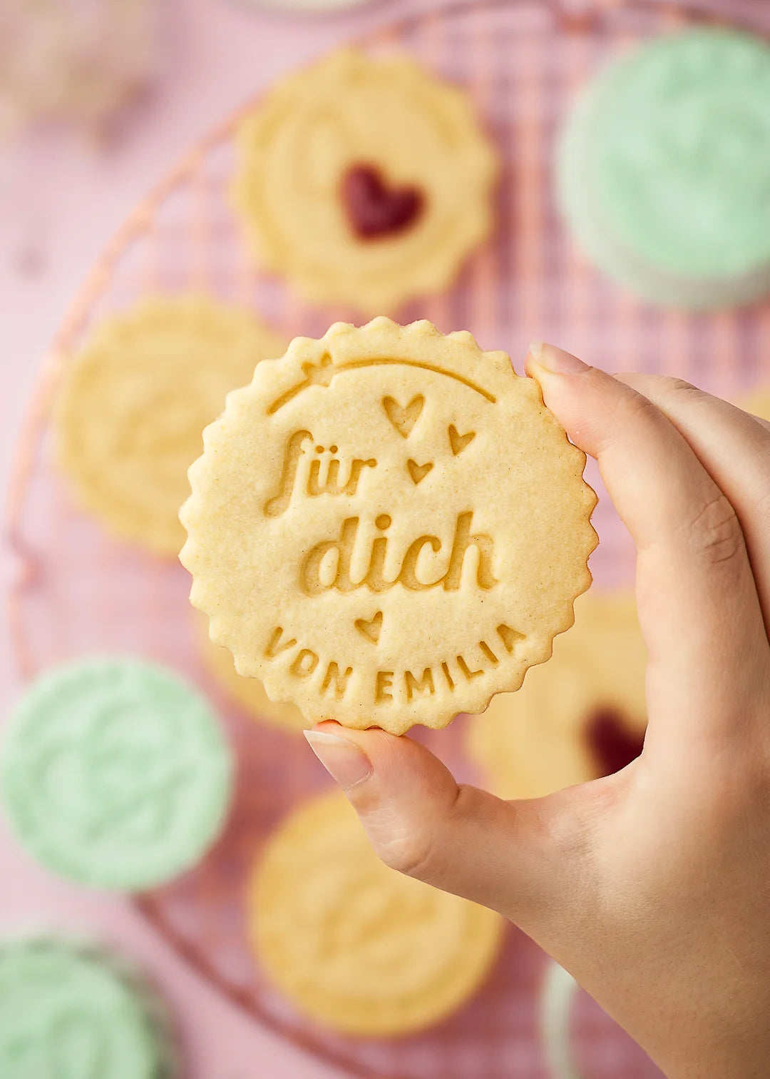 Hand holding a cookie stamped with the message “für dich – von Emilia” and heart decorations. Made using our personalized cookie stamp – perfect for gifting, thank-you bakes, or adding a custom touch to your cookies.