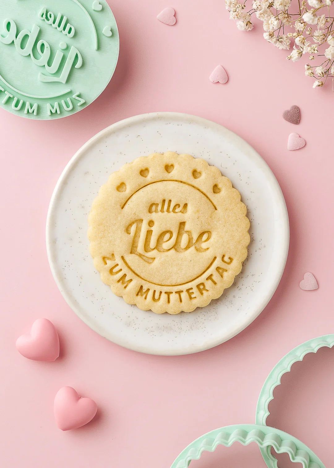 Mother’s Day cookie with the message “Alles Liebe zum Muttertag” stamped in perfect detail, placed on a ceramic plate. Made using our custom cookie stamp and cutter – ideal for gifting baked love to mom.