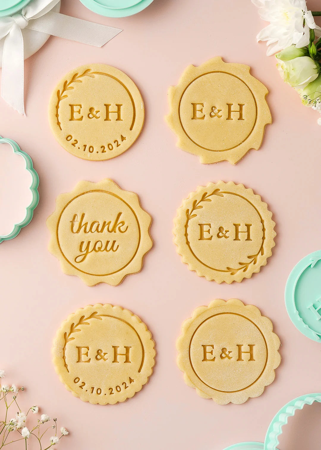 Stamped wedding cookies with names, initials, date, and thank you messages made using round personalized cookie cutters and stamps.