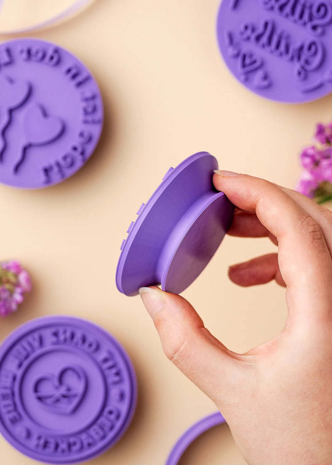 Hand holding cookie stamp, showing its ergonomic handle design