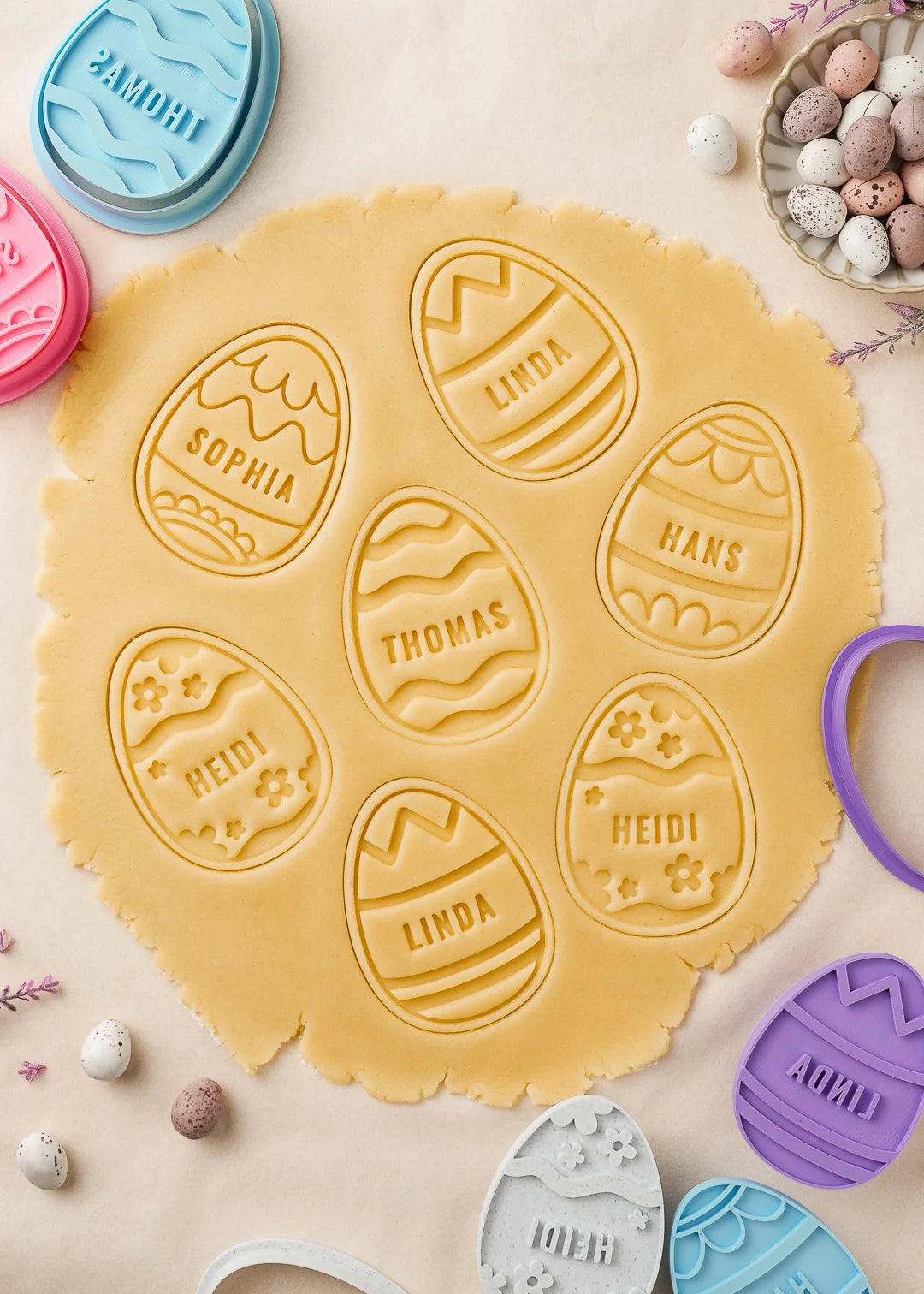 Easter egg cookie stamps pressed on rolled out cookie dough