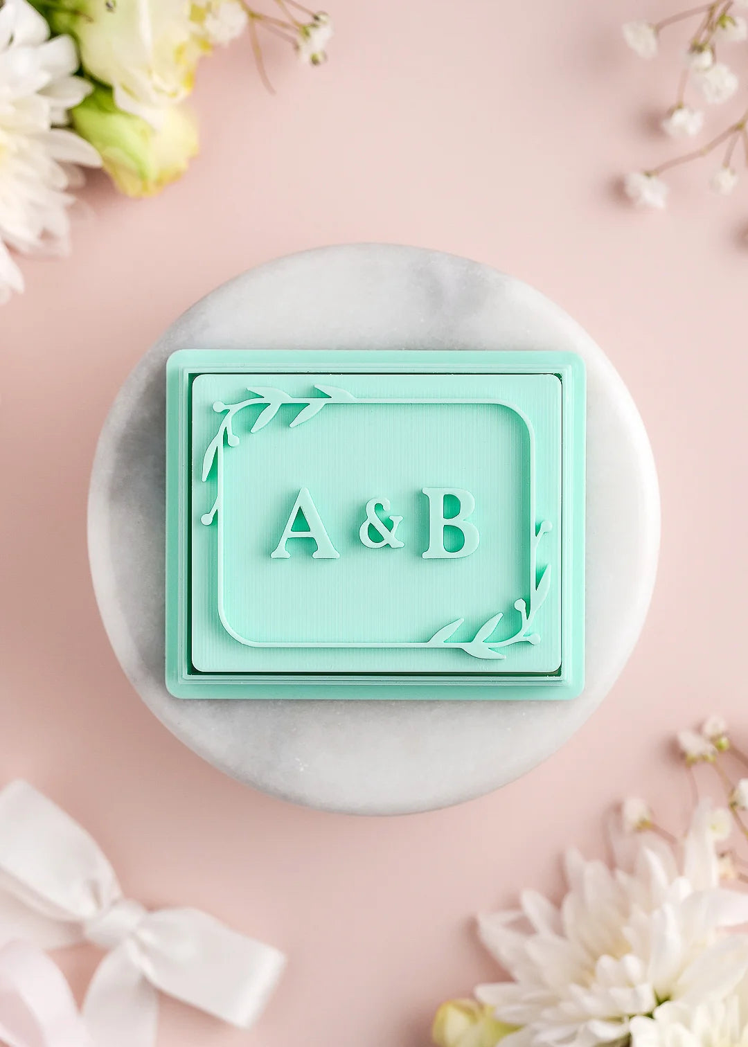 Rectangular wedding cookie stamp with custom initials and floral frame. Example: A&B