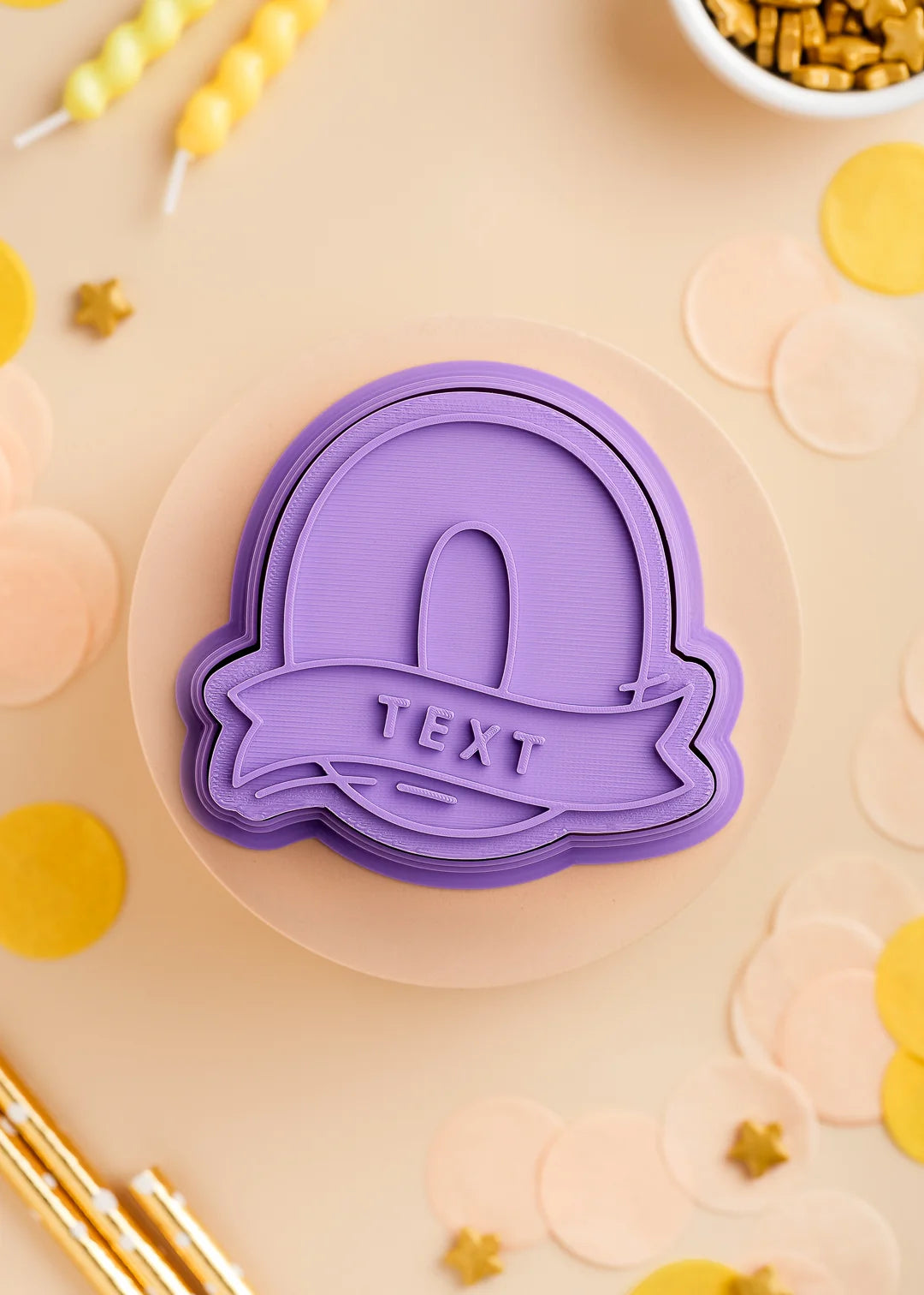 Purple number zero cookie stamp with cutter with custom name, perfect for a kids birthday party. Surrounded by pastel confetti and party-themed decorations.