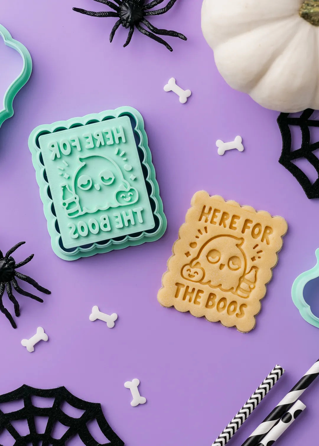 Halloween-themed cookie stamp with 'Here for the Boos' text and tipsy ghotst on a purple background with spider webs and pumpkins.