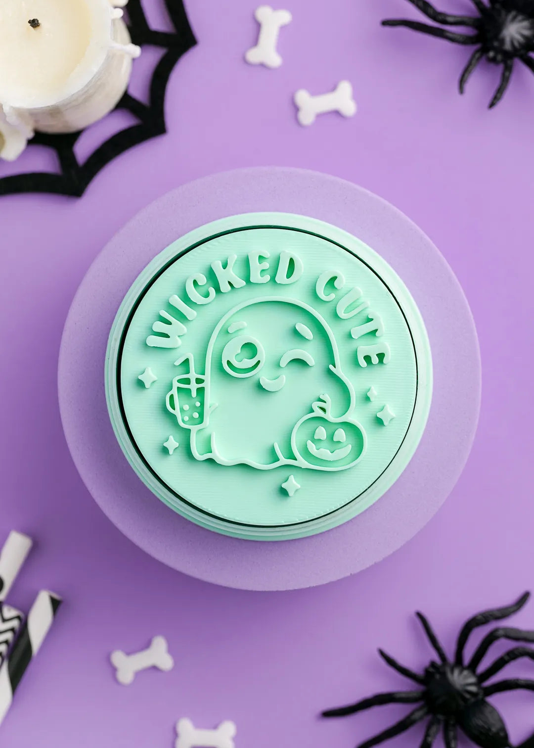 Green cookie stamp with 'Wicked Cute' text and adorable ghost on a purple background with Halloween decorations.