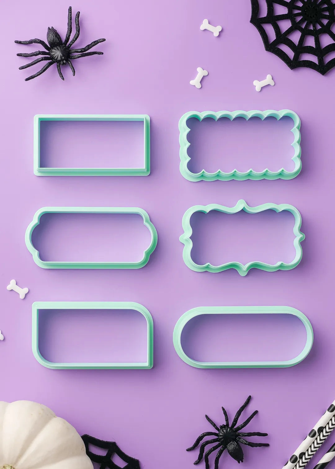 6 options of green cookie cutters on a purple background with Halloween decorations.